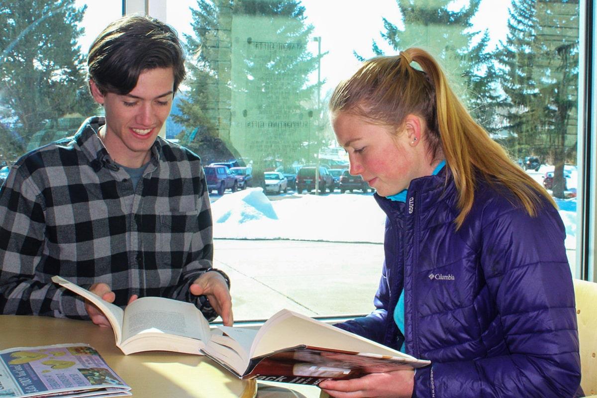 Naiya and team member reading at table