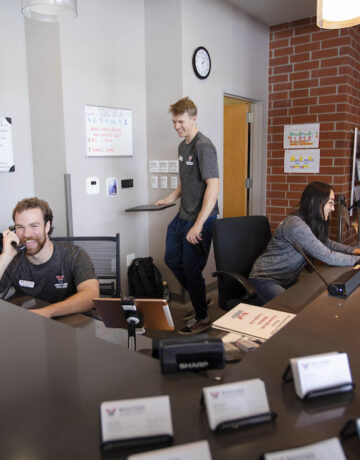 A photo of a few of the Mountaineer Field House staff at the front desk.