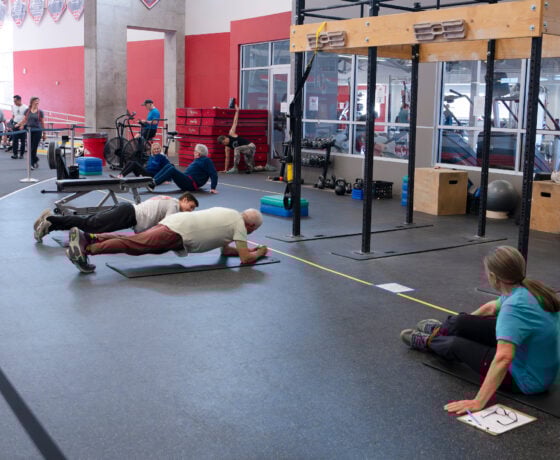 A photo of a couple of pairs of students and community members doing exercises and stretches for the Wellness Elevated program.