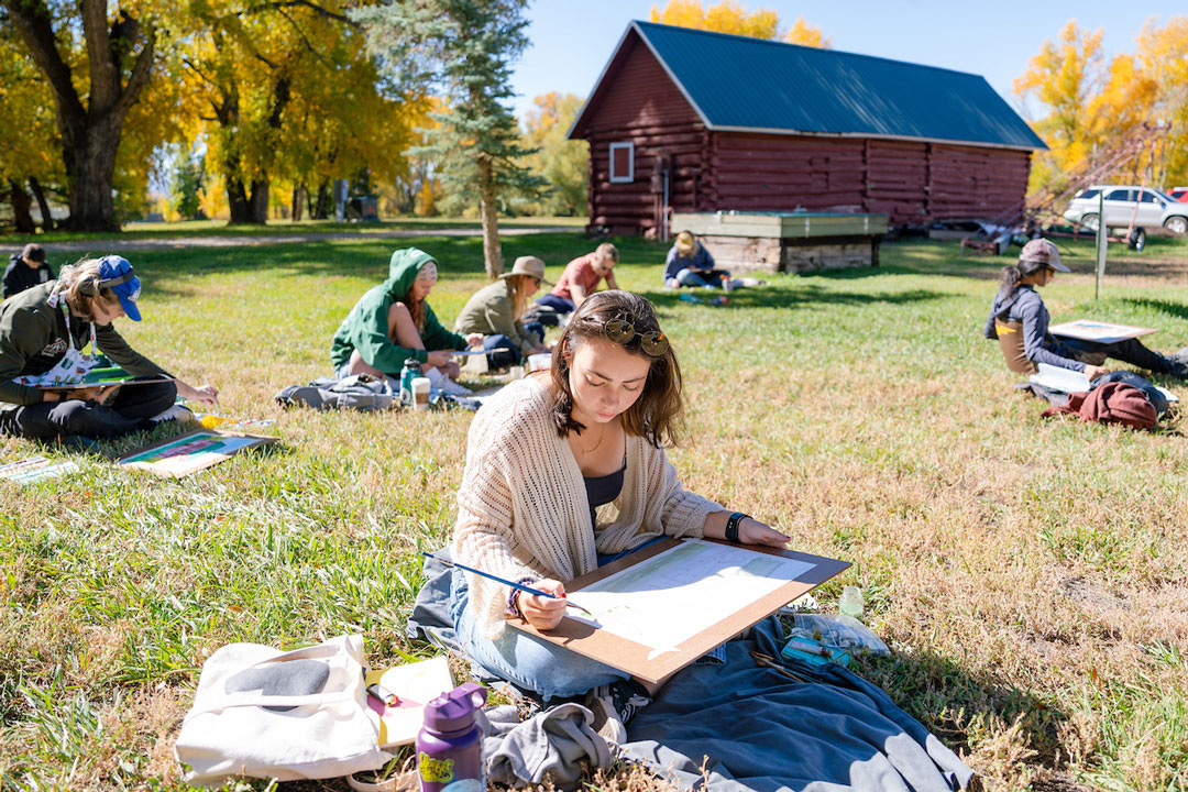 Students painting near barn