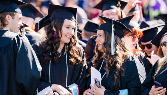 Graduates smile big as they enter the Mountaineer Bowl during commencement.