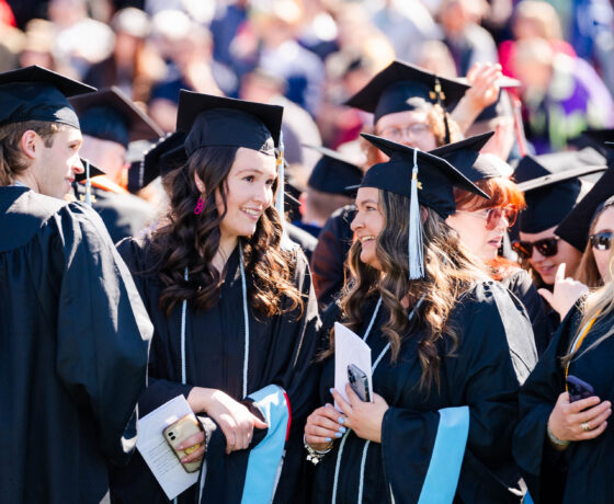 Graduates smile big as they enter the Mountaineer Bowl during commencement.