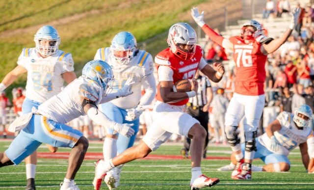 Western player #12 runs into the endzone with Fort Lewis players right behind him and Western player #76 celebrating the touchdown