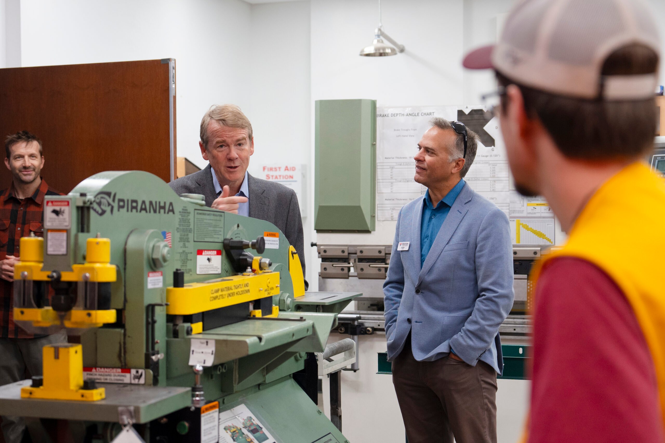 Senator Bennet converses with some engineering students in the fabrication shop during a tour of the Rady School of Engineering.