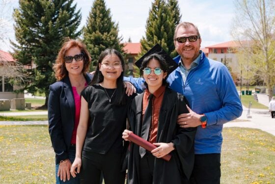 A family smiles with their graduate.