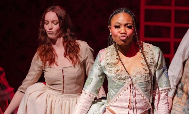 Two students dance in Victorian era costumes during a play.