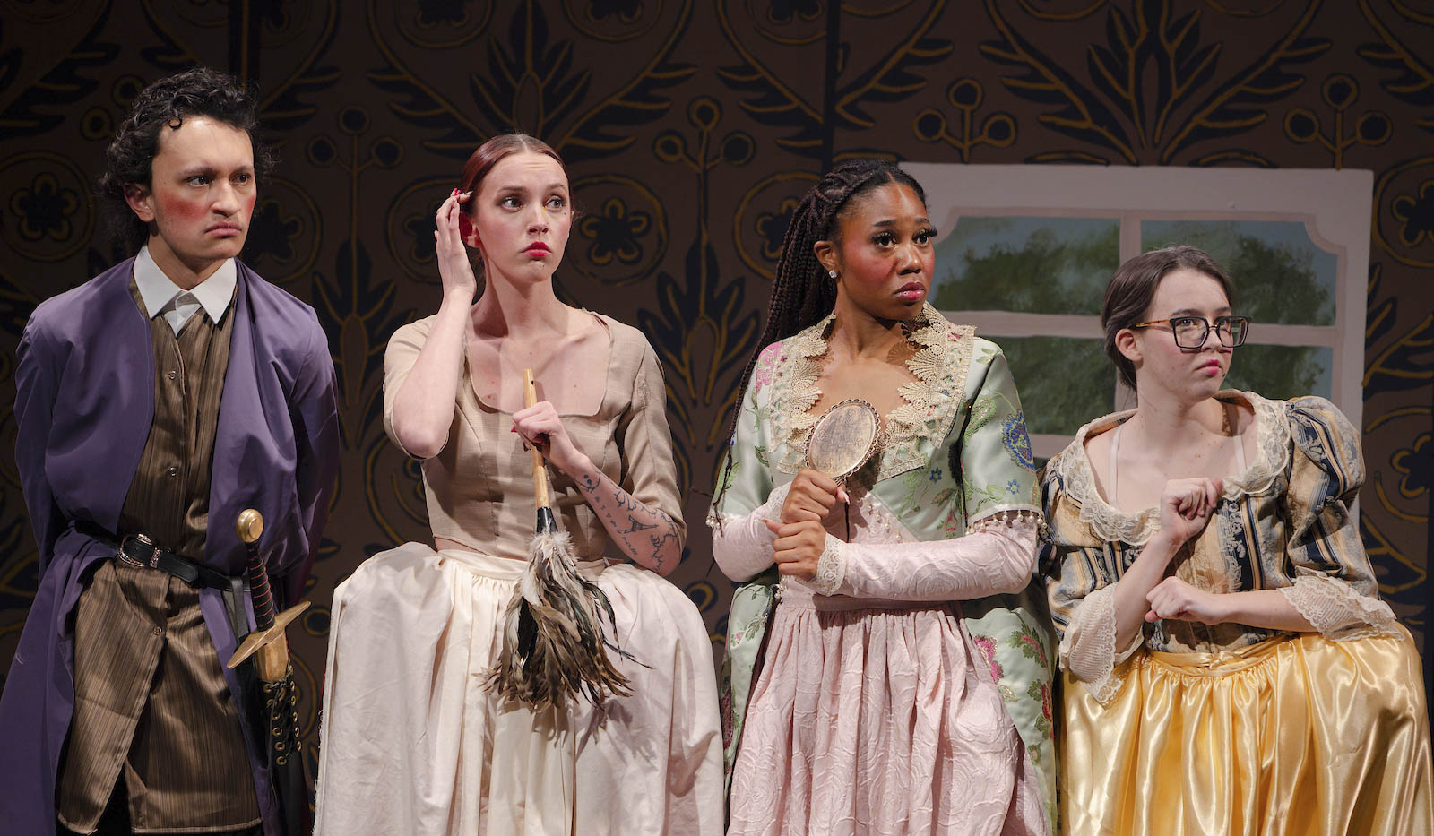 Part of the Tartuffe cast lines up against the wall and make dramatic expressions.
