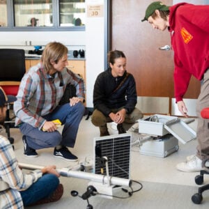 A couple of people from the Rocky Mountain Biological Lab look over the partially assembled sensor suite build by some engineering students.