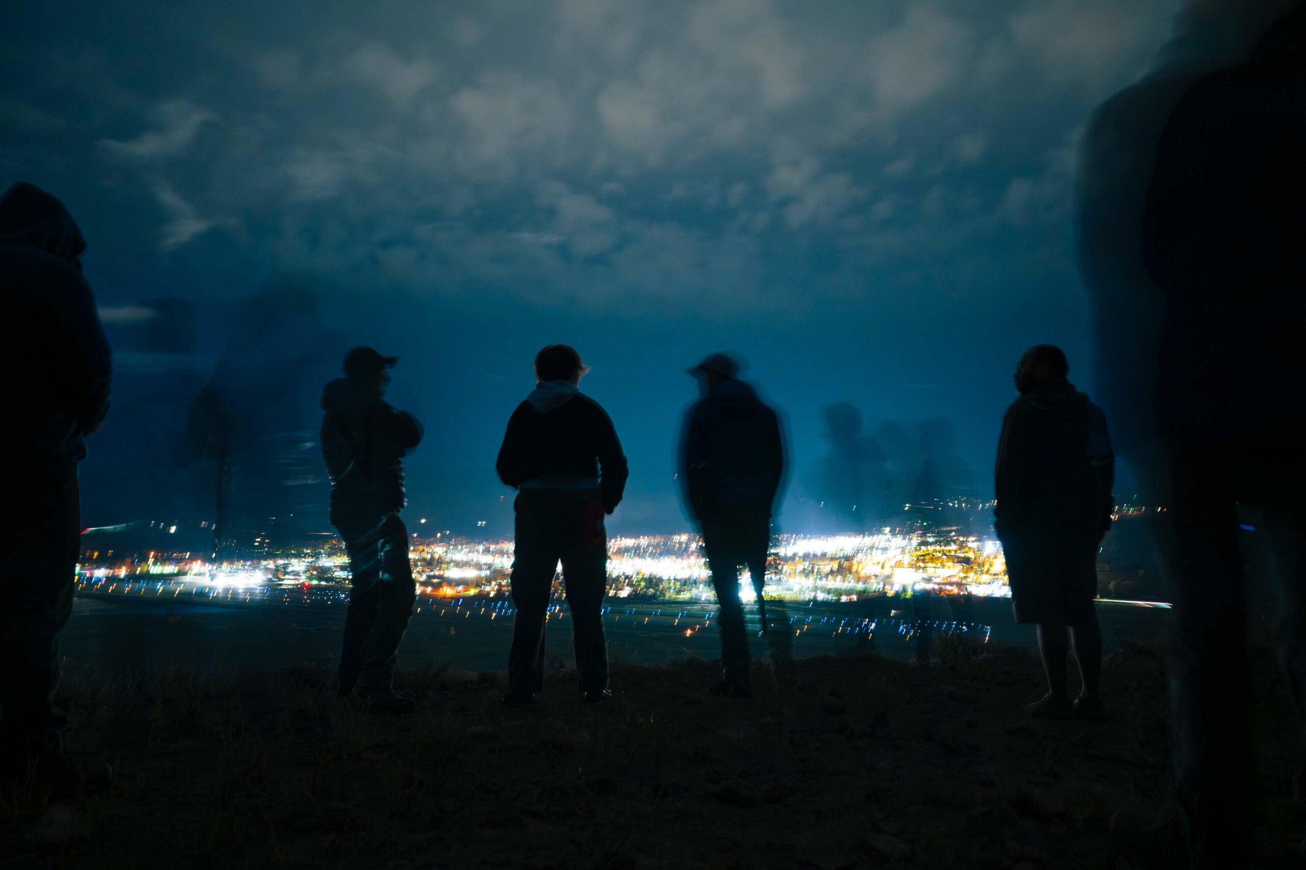 Members of the Mountain Rescue Team look down at the town of Gunnison from W Mountain while they wait for it io get dark enough to light the W.