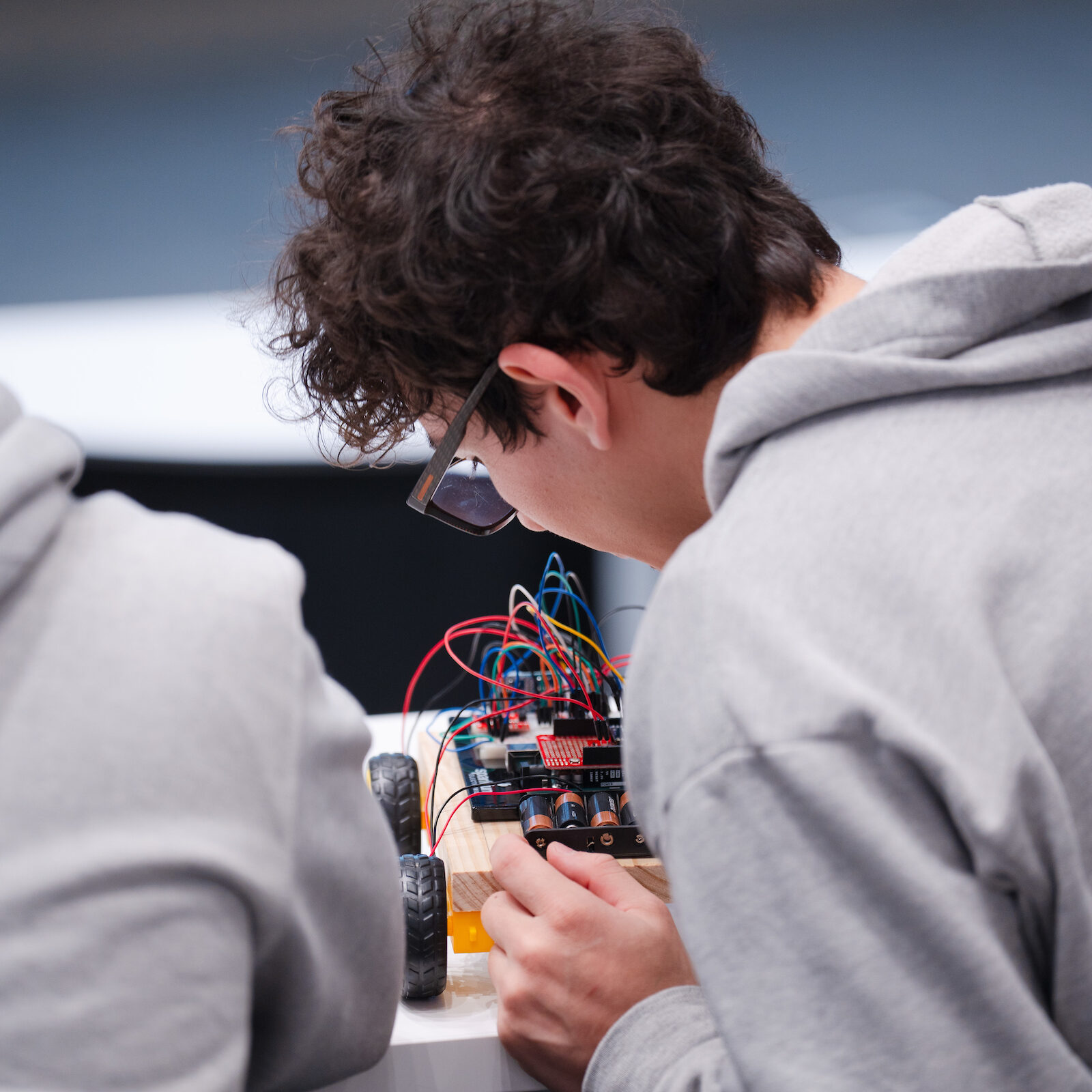 Two students look over and discuss their RC car before a demonstration for their 'Internet of Things' computer science class.