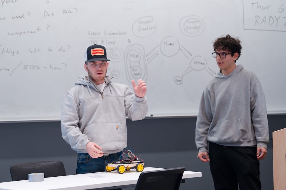 A pair of students present their final project for the 'Internet of Things' computer science class.