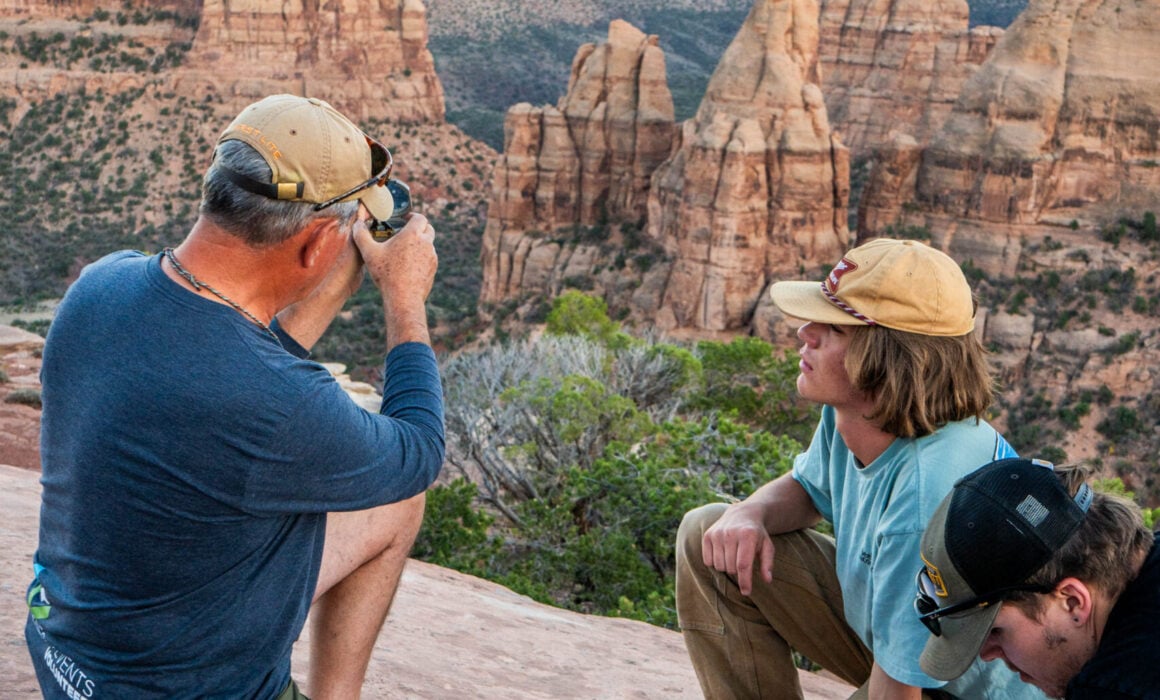 Students identify rock layers with their geology professor at Colorado National Monument.