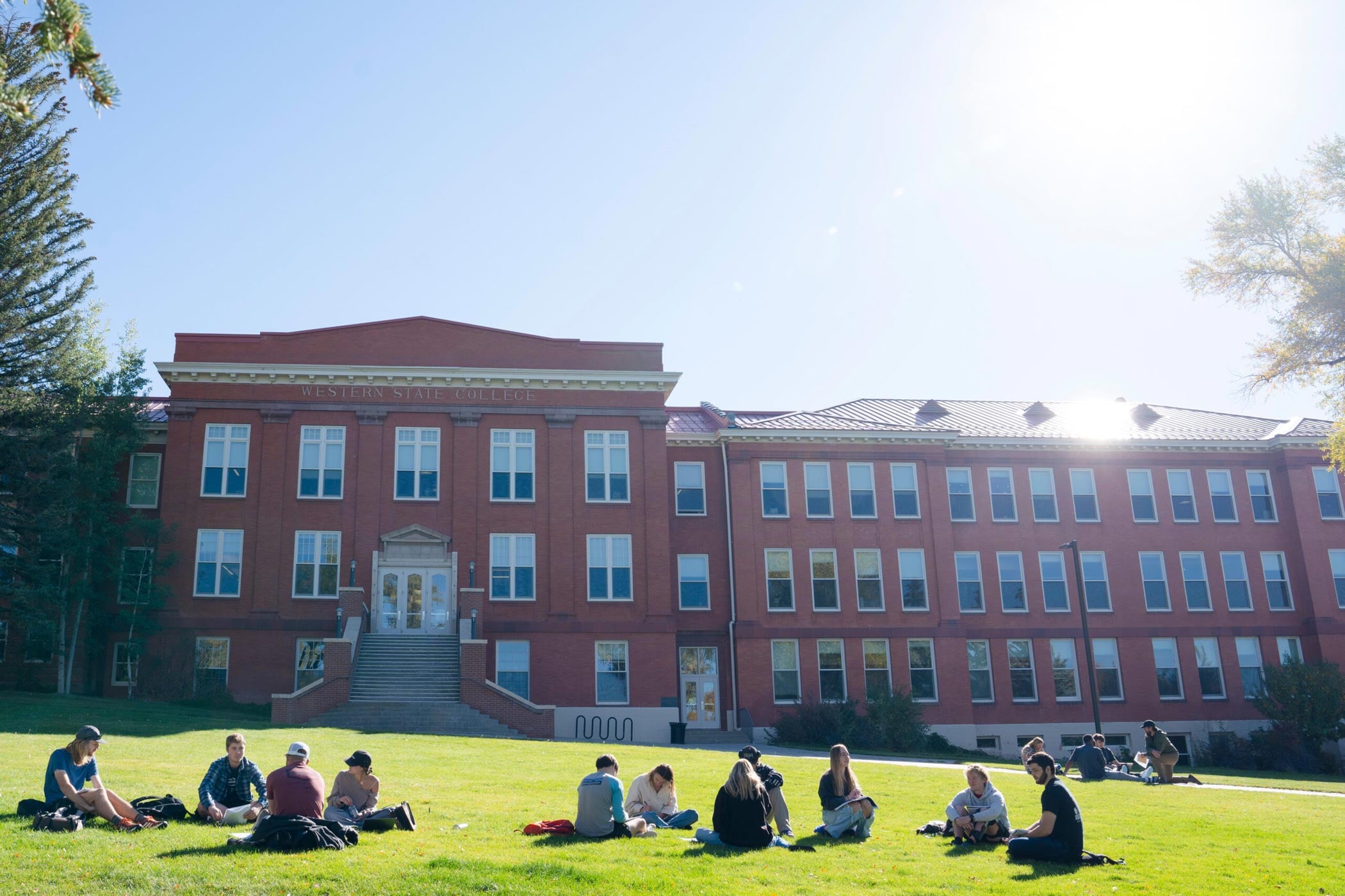 Groups of students sit on Taylor Lawn and discuss an assignment for a philosophy class.