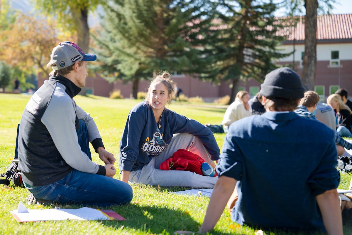 A student talks during a group activity for a philosophy class while sitting on Taylor Lawn.