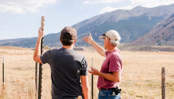 Pat Magee instructs a student holding a post at Verzuh Ranch. Whetstone Mountain can be seen in the background.