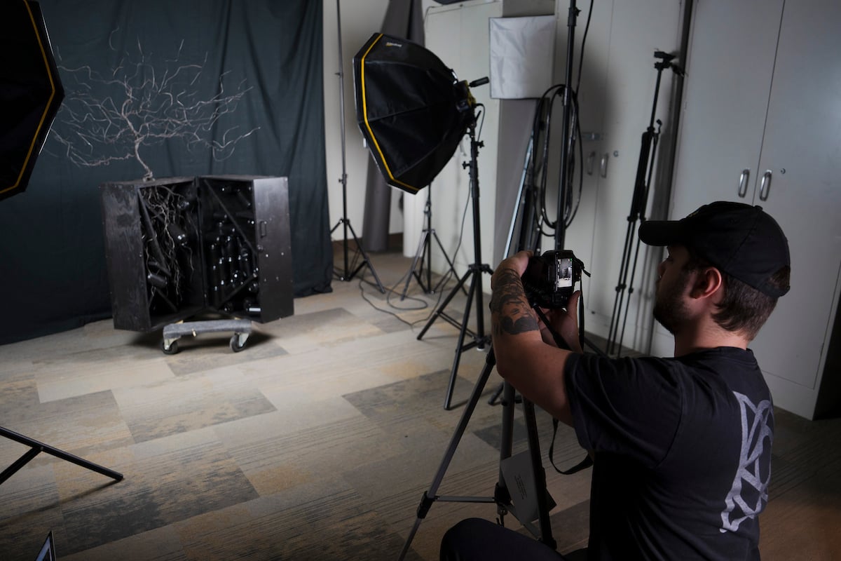 An art student takes a photo of a tree sculpture during the Pathfinder Magazine Submission Festival.