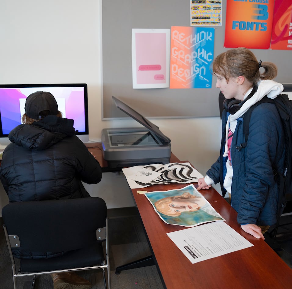 A couple of art students scan a painting into Photoshop during the Pathfinder Magazine Submission Festival.