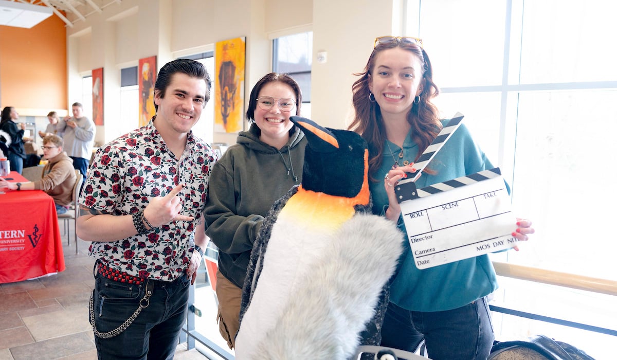 The KWSB team poses next to a stuffed penguin during the club fair.