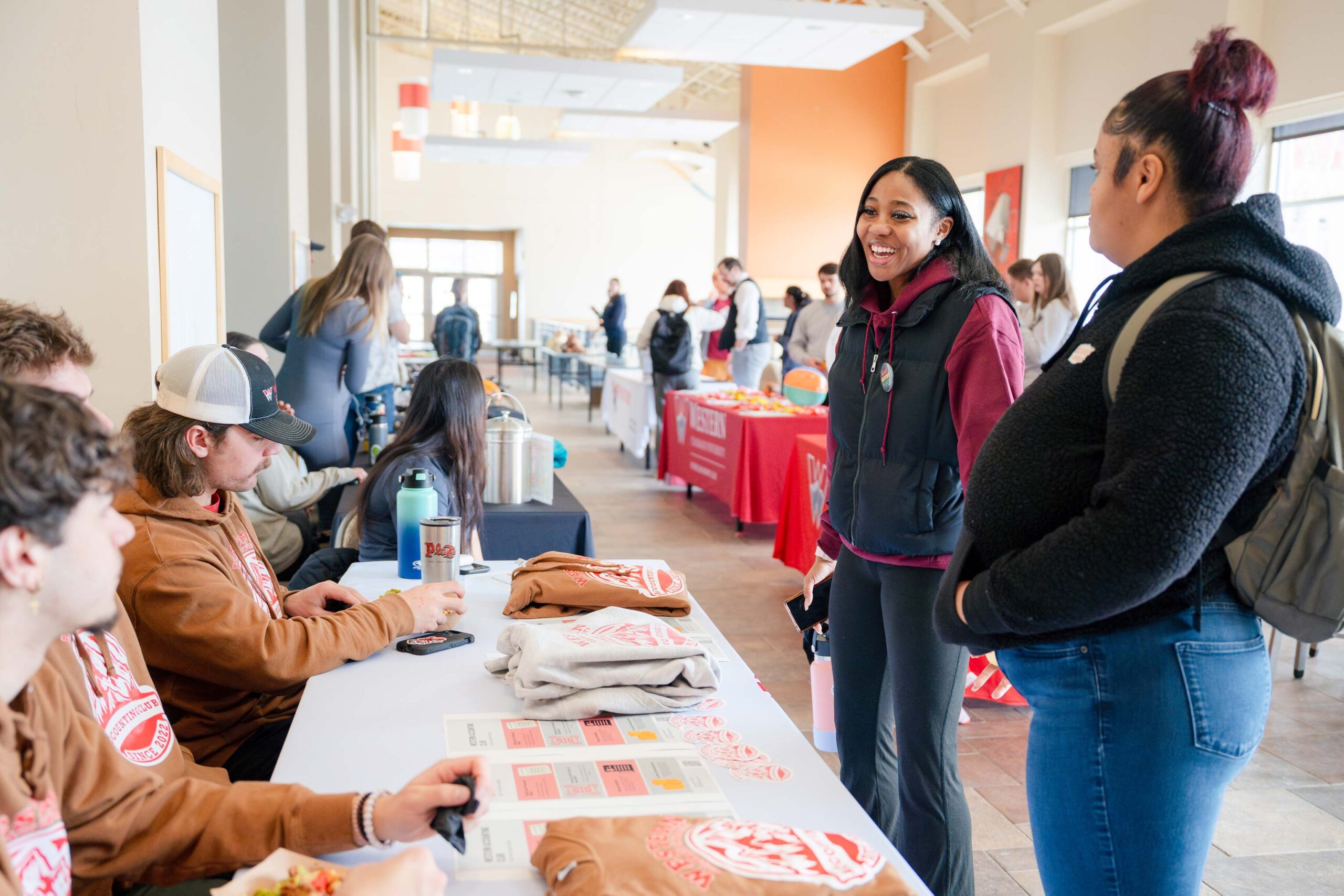 Two girls visit a table during the club fair in the University Center