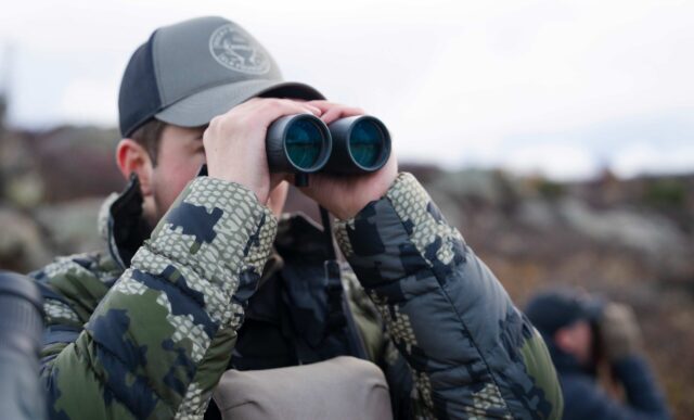 Graduate student, Cody Hinkley, glasses for big horn sheep while standing on the Painted Wall Overlook in the Black Canyon of the Gunnison National Park.