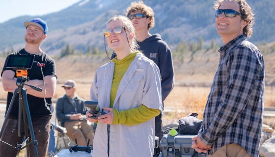 Professor Micah Russell shows a student how to fly the drone