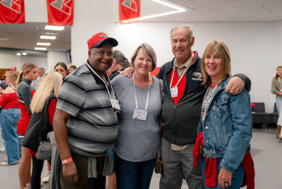 Four alumni gather for a group photo during the Lighting of the W Party