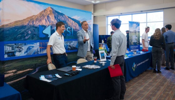 A student talks with an employer during a career and internship fair.