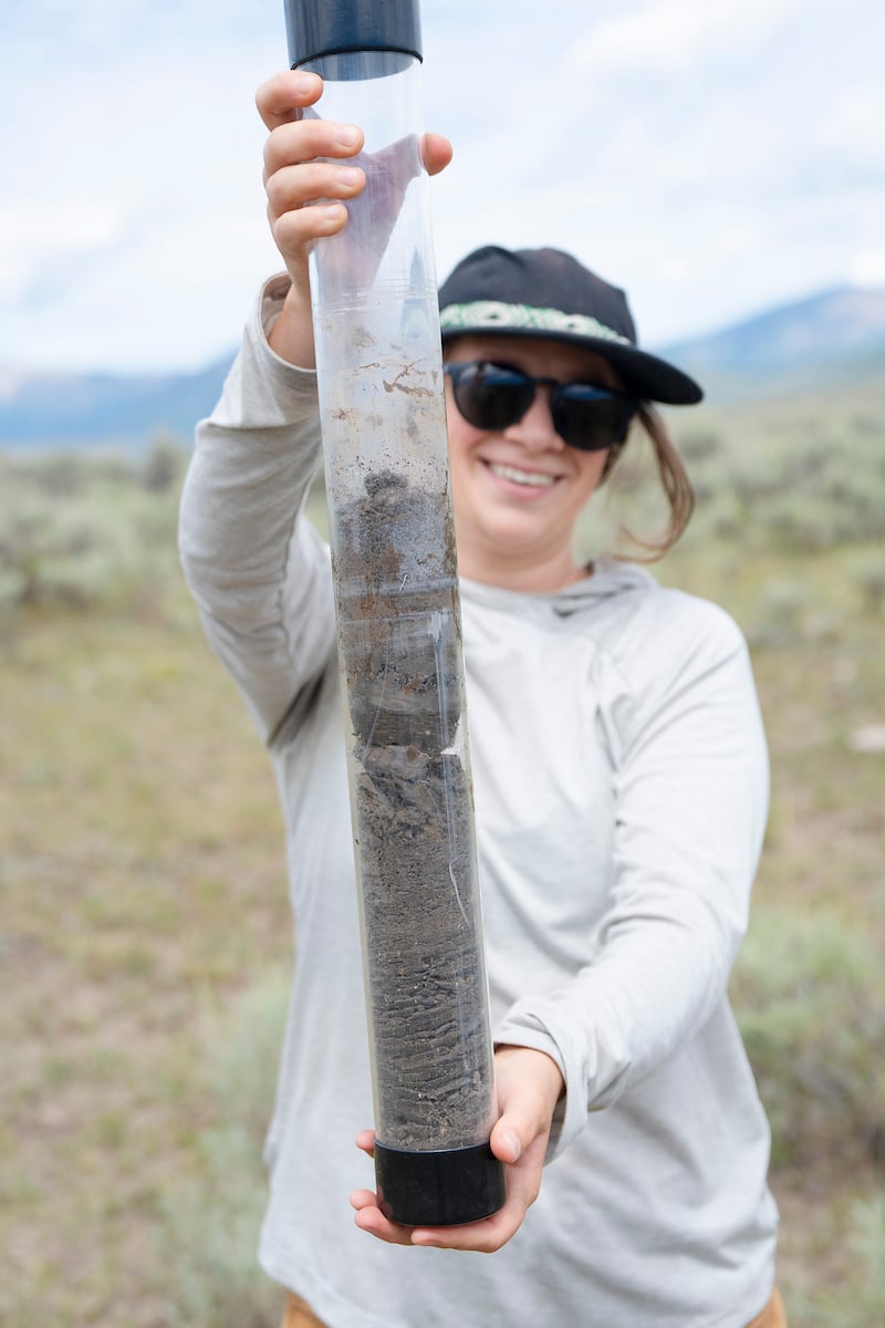 MSE student Phoebe Roberts holds up the soil core sample retrieved at a site for her graduate project.