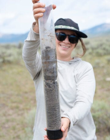 MSE student Phoebe Roberts holds up the soil core sample retrieved at a site for her graduate project.