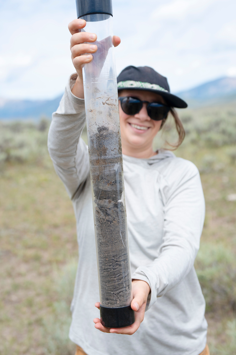 MSE student Phoebe Roberts holds up the soil core sample retrieved at a site for her graduate project.