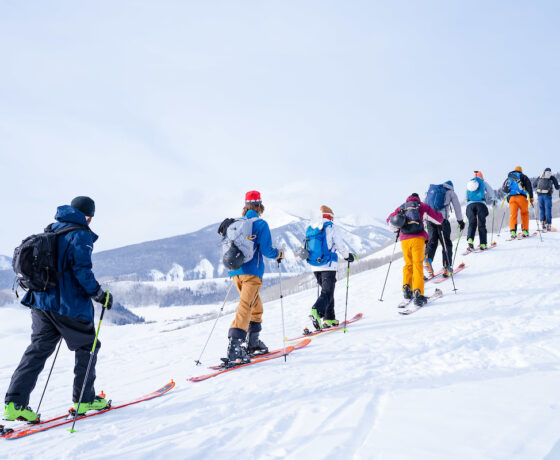 A large group from a Recreation & Outdoor Education class skins up Snodgrass Mountain in single file.