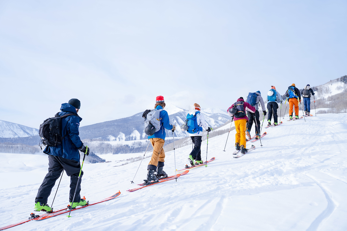 A large group from a Recreation & Outdoor Education class skins up Snodgrass Mountain in single file.