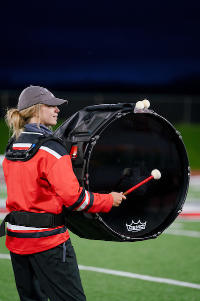 A member of the Western drumline plays the bass drum on the field at half-time.
