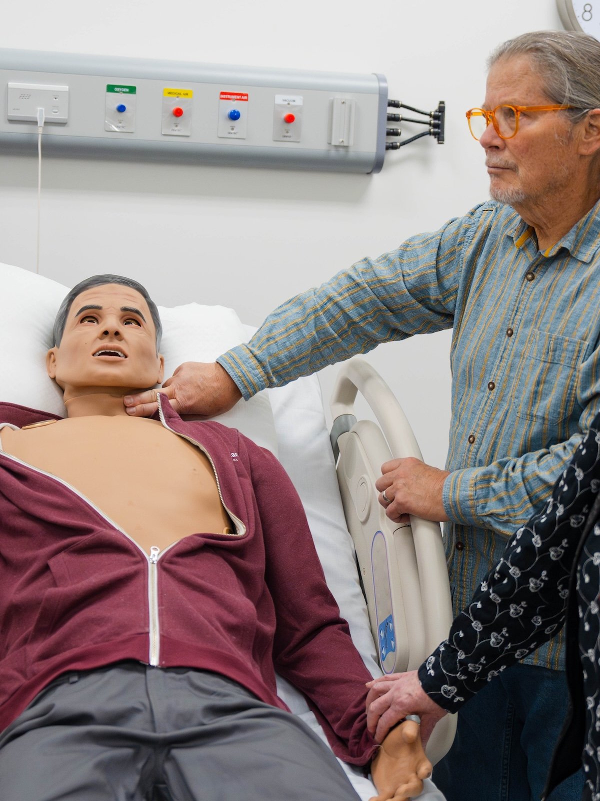 Dr. Jeff Oster demonstrates taking a pulse on a dummy.