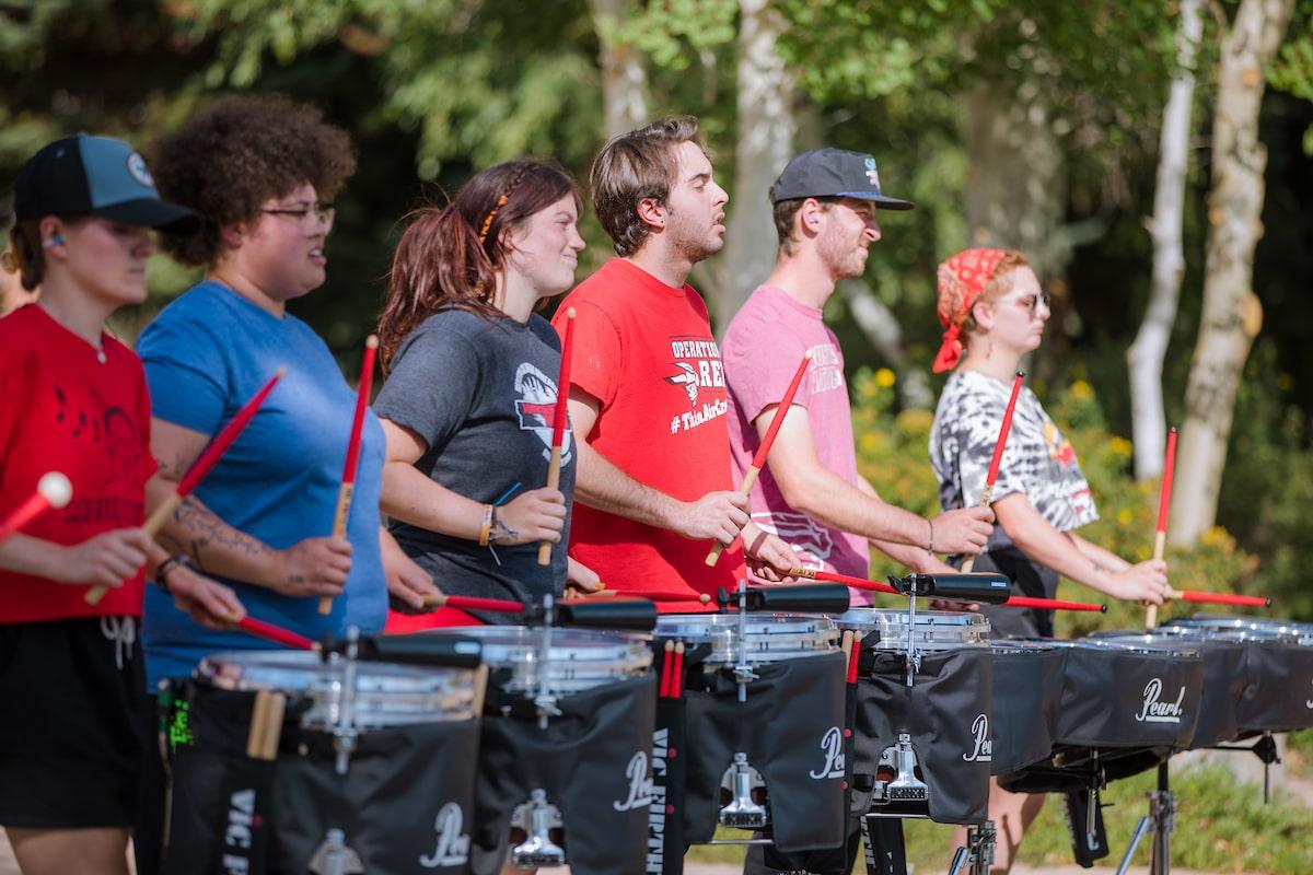 Line of snare drum performers on campus