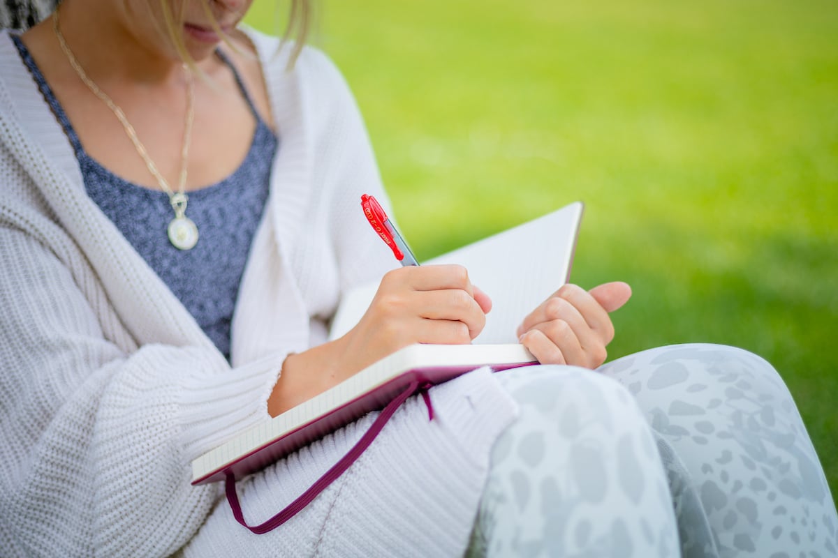 A close up shot of a student writing in her journal on Taylor Lawn