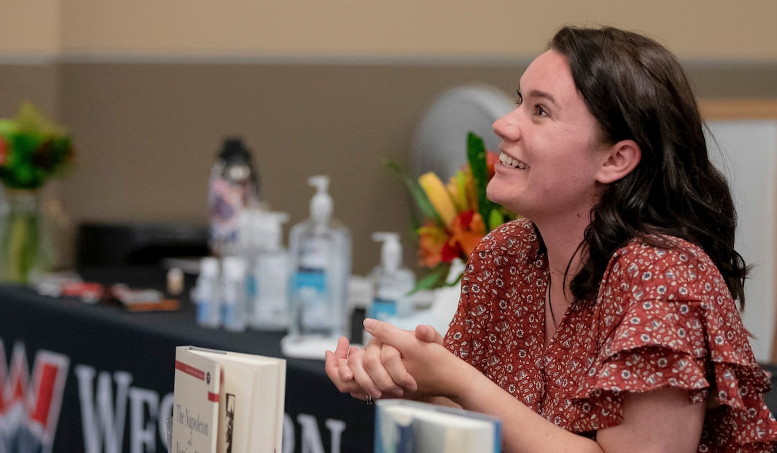 A student editor smiles with the book she helped rework