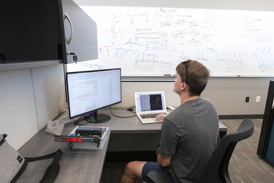 A student codes in a small classroom.