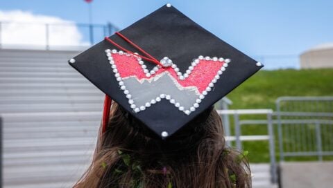A Western grad shows off her cap decorated with a Western W