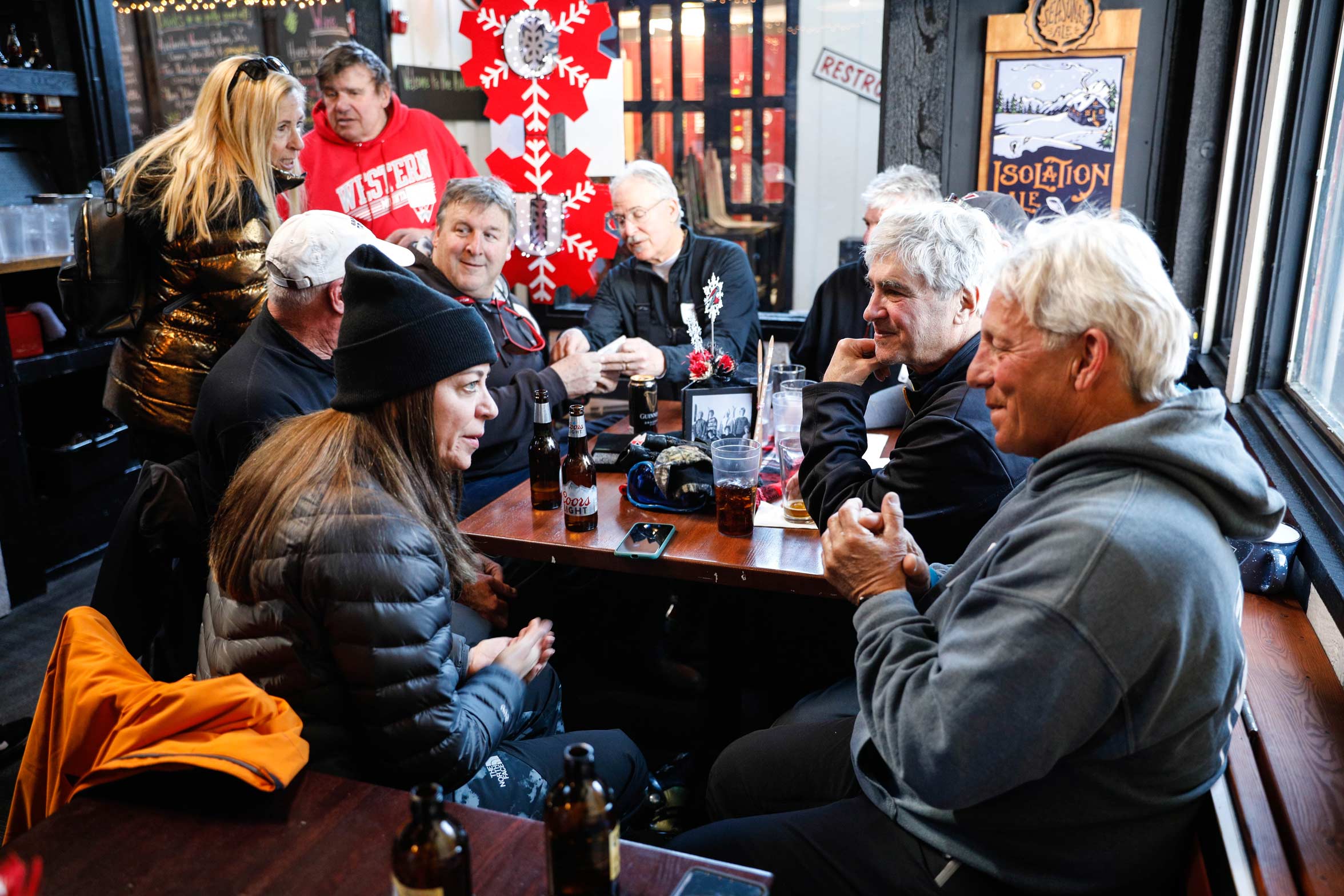 Nancy Chisholm sits at a table and talks with a group of Western Alumni.
