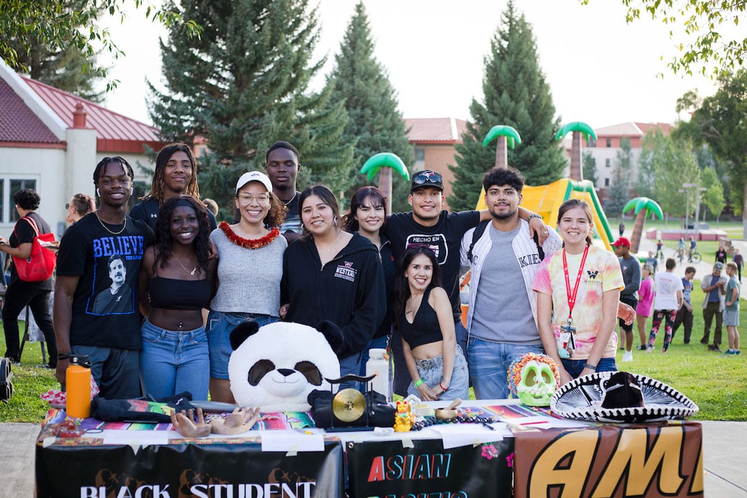 A group of students pose for a photo together at the Multicultural Center club table at A Taste of Western.