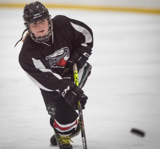 A Western women's hockey player shoots the puck and scores a goal.