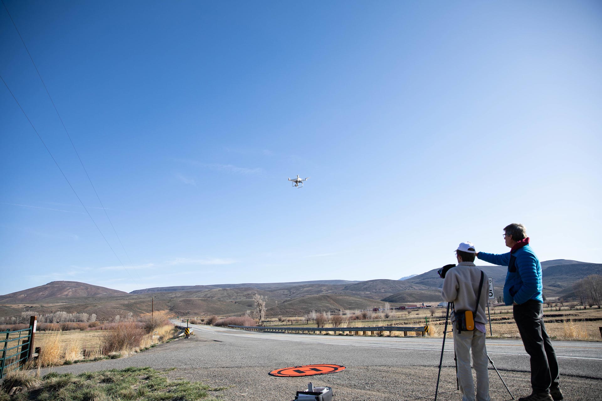 Dr. Crossley coaches student Everett Fillmore as he launches the drone.