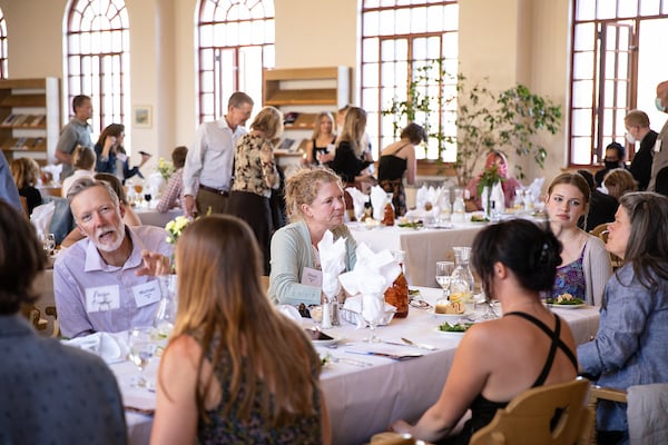 A table full of guests for one of the award recipients sit and mingle at a table over salad and drinks.