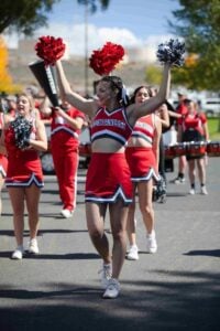 Western cheerleader performing on main street with hands up
