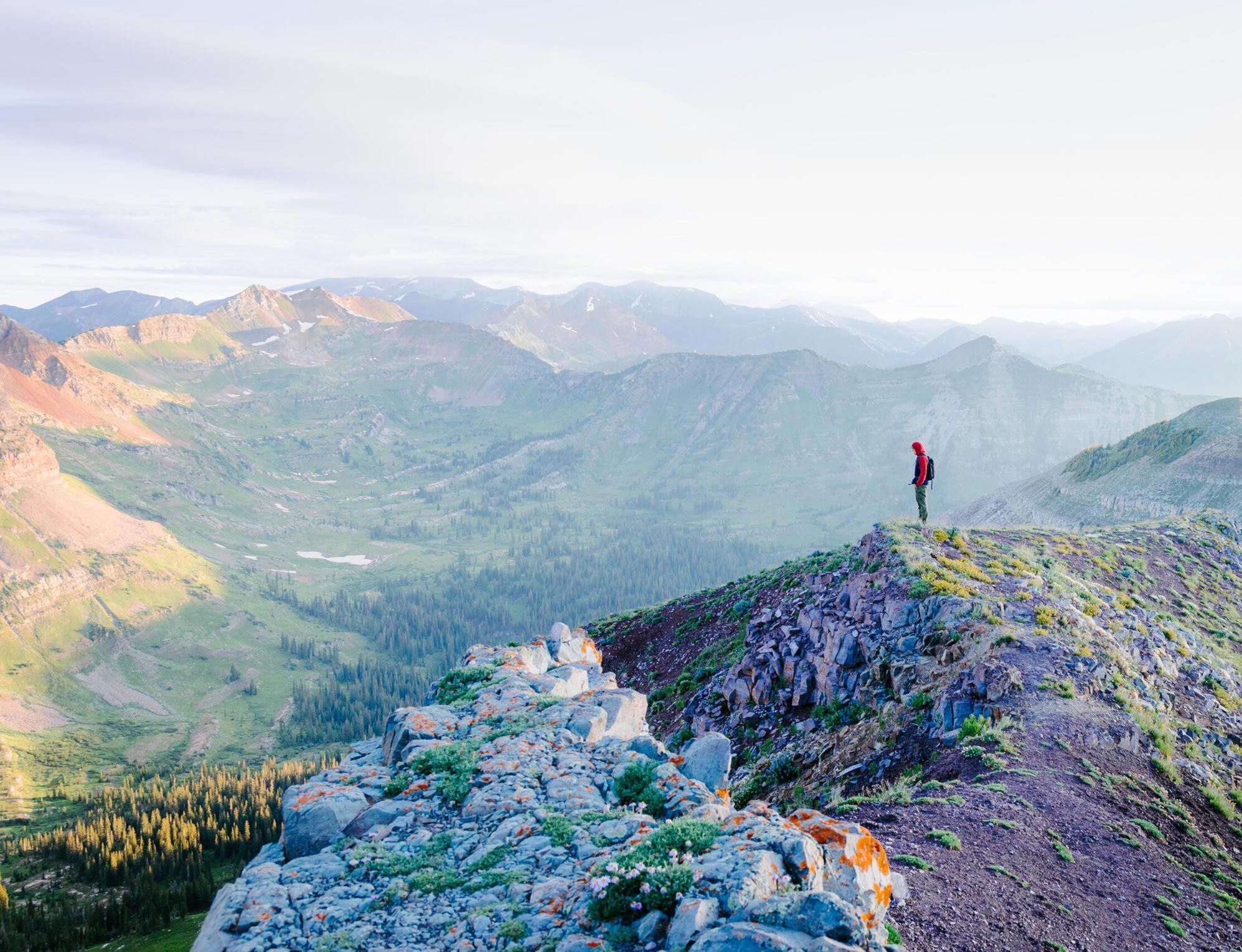 A student stands on a ridgeline at sunrise