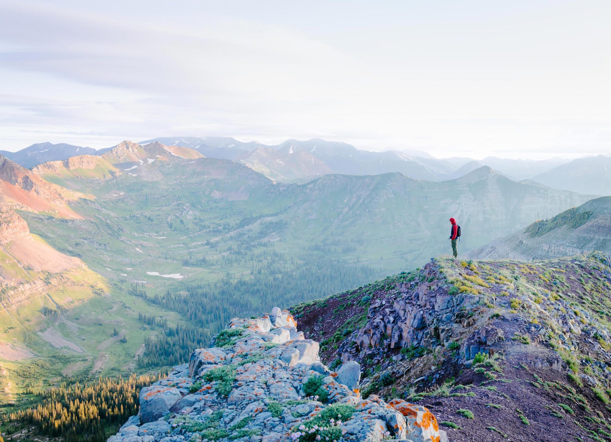A student stands on a ridgeline at sunrise