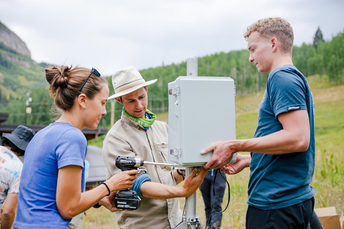 An engineering student and two RMBL employees build a weather station together in Gothic, Colorado.