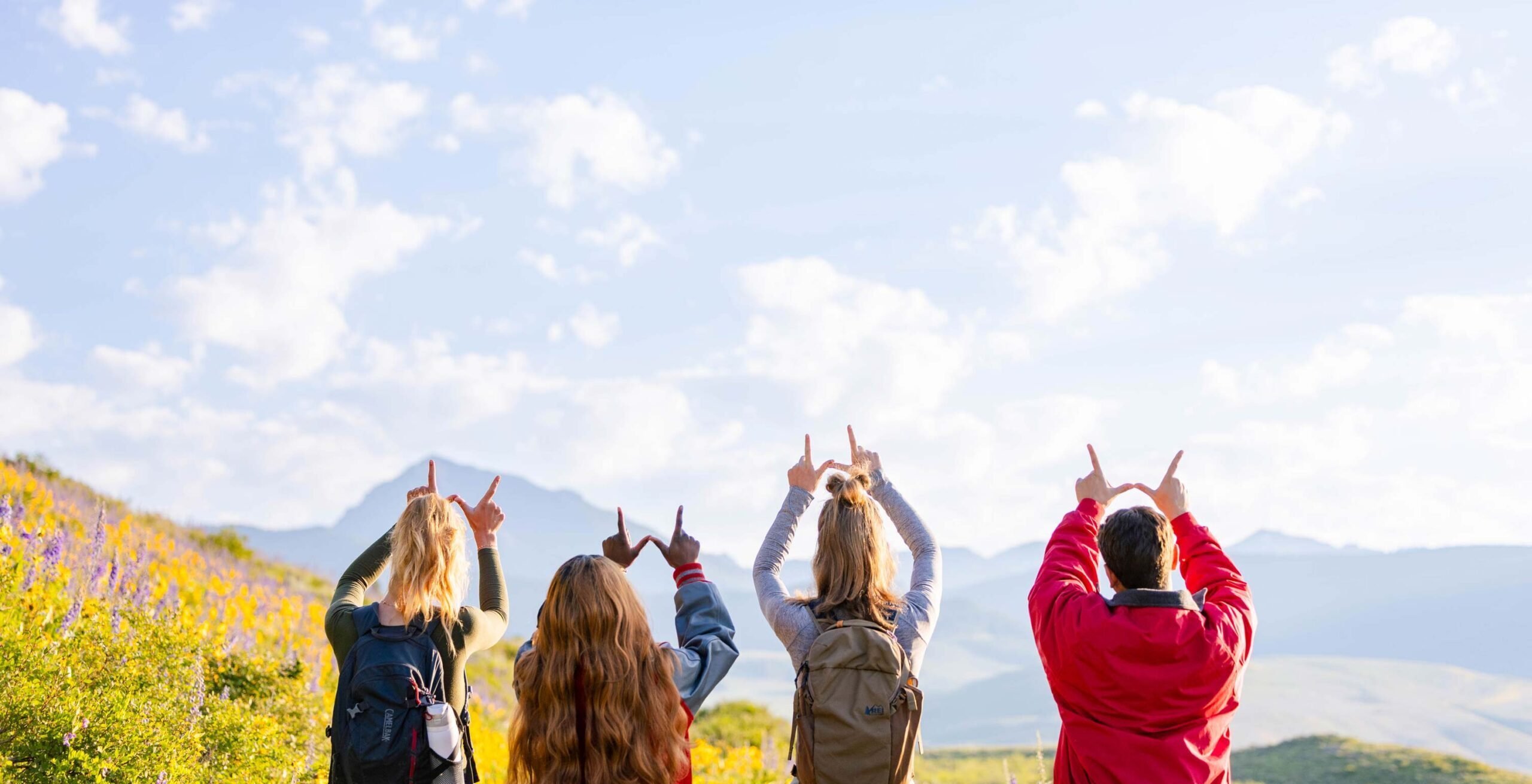 Students hold up the W with Teocalli in the background.