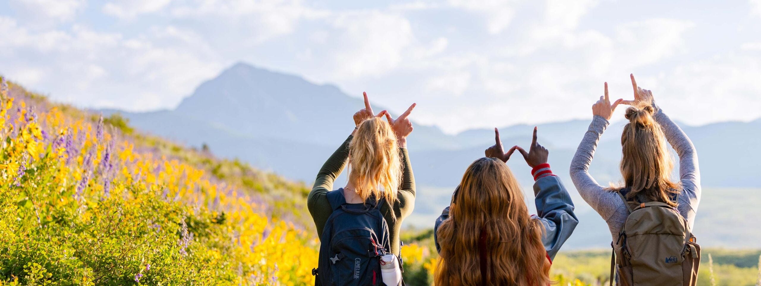 Students hold up the W with Teocalli in the background.
